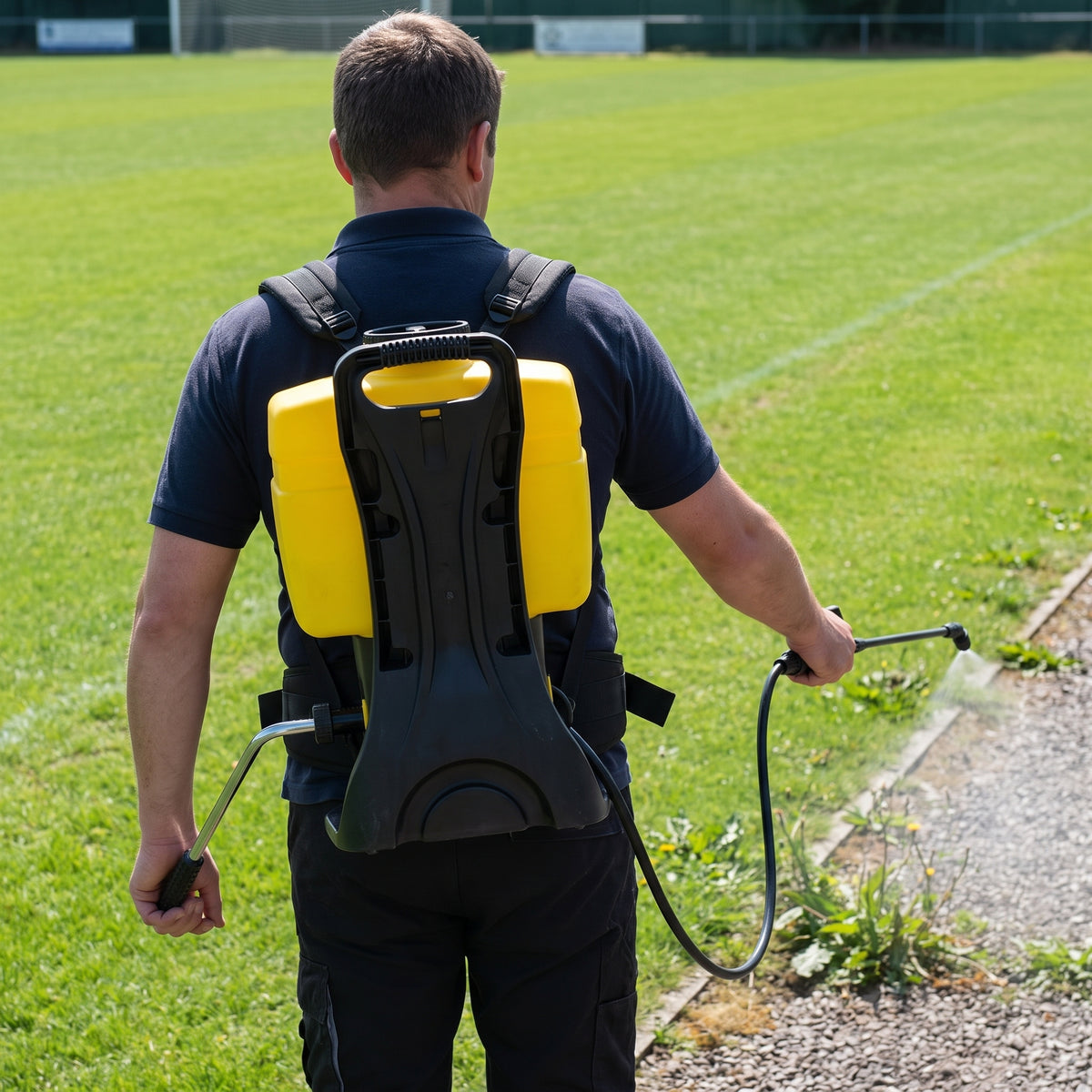 16L knapsack sprayer with contoured back-frame worn while spraying weeds along a path