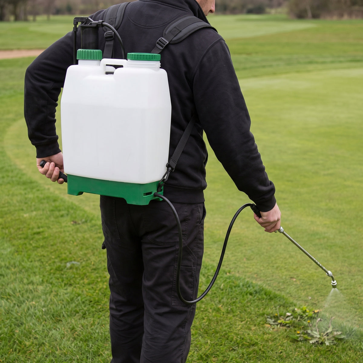 16L knapsack sprayer worn on adjustable shoulder straps, spot-spraying weeds on a golf course