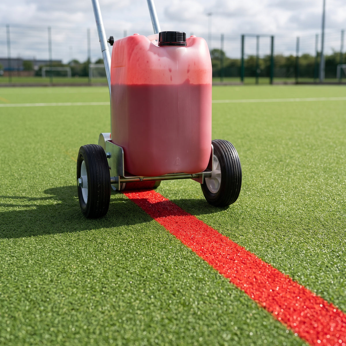 Red water-based line marking paint applied by spray marker on a synthetic all-weather pitch