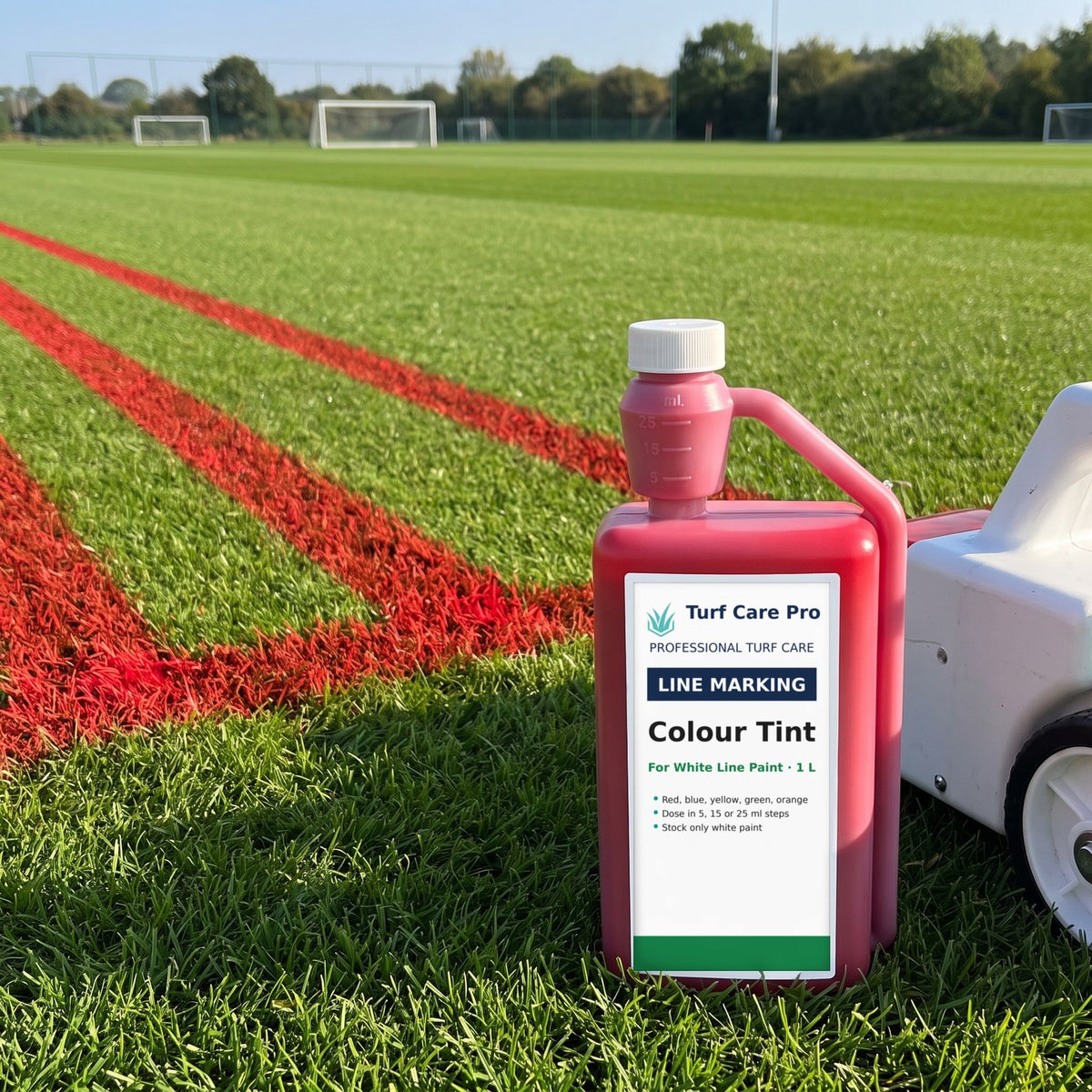 1L colour tint bottle with dosing chamber beside a line marker and red lines on a football pitch