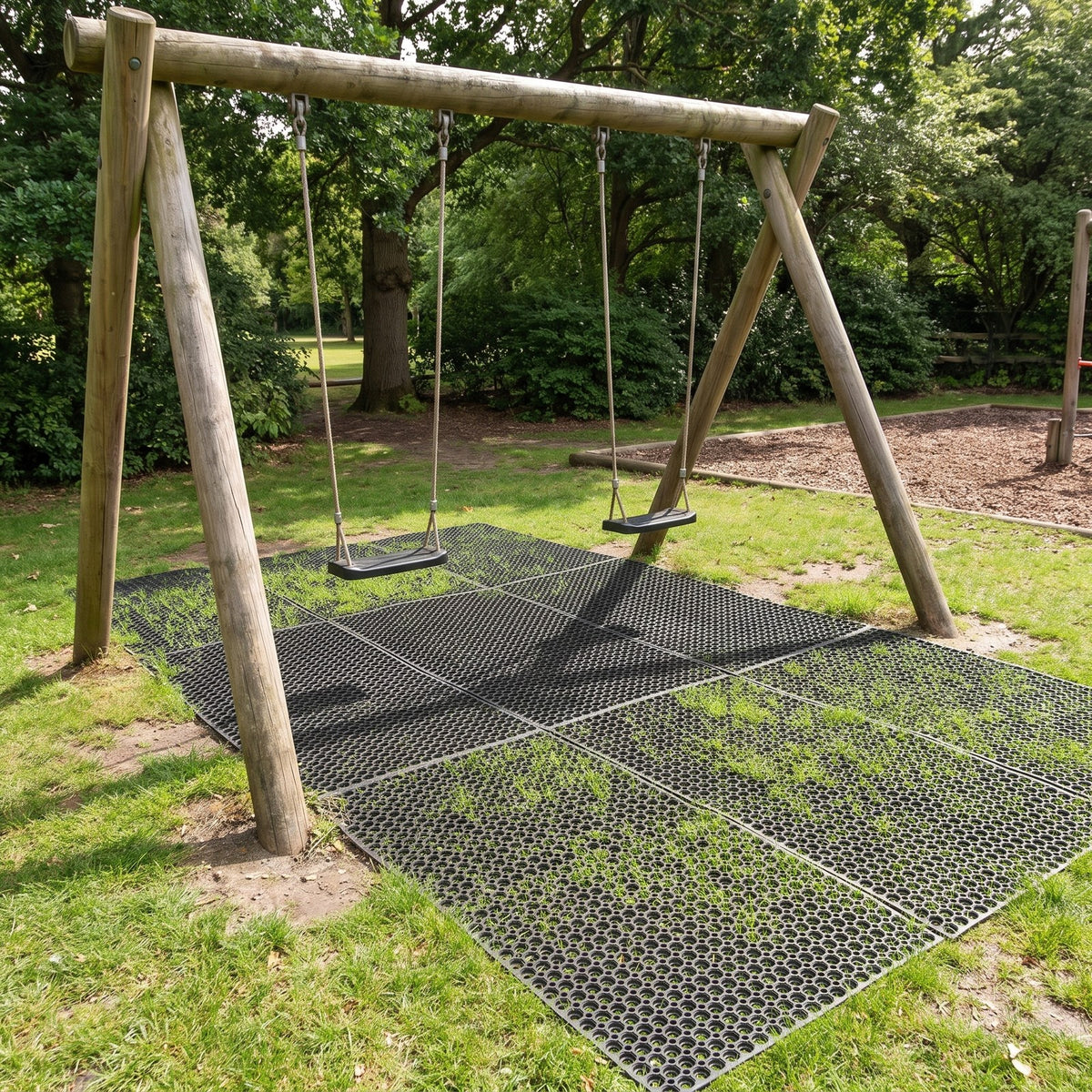 Rubber grass safety mats laid under playground swings