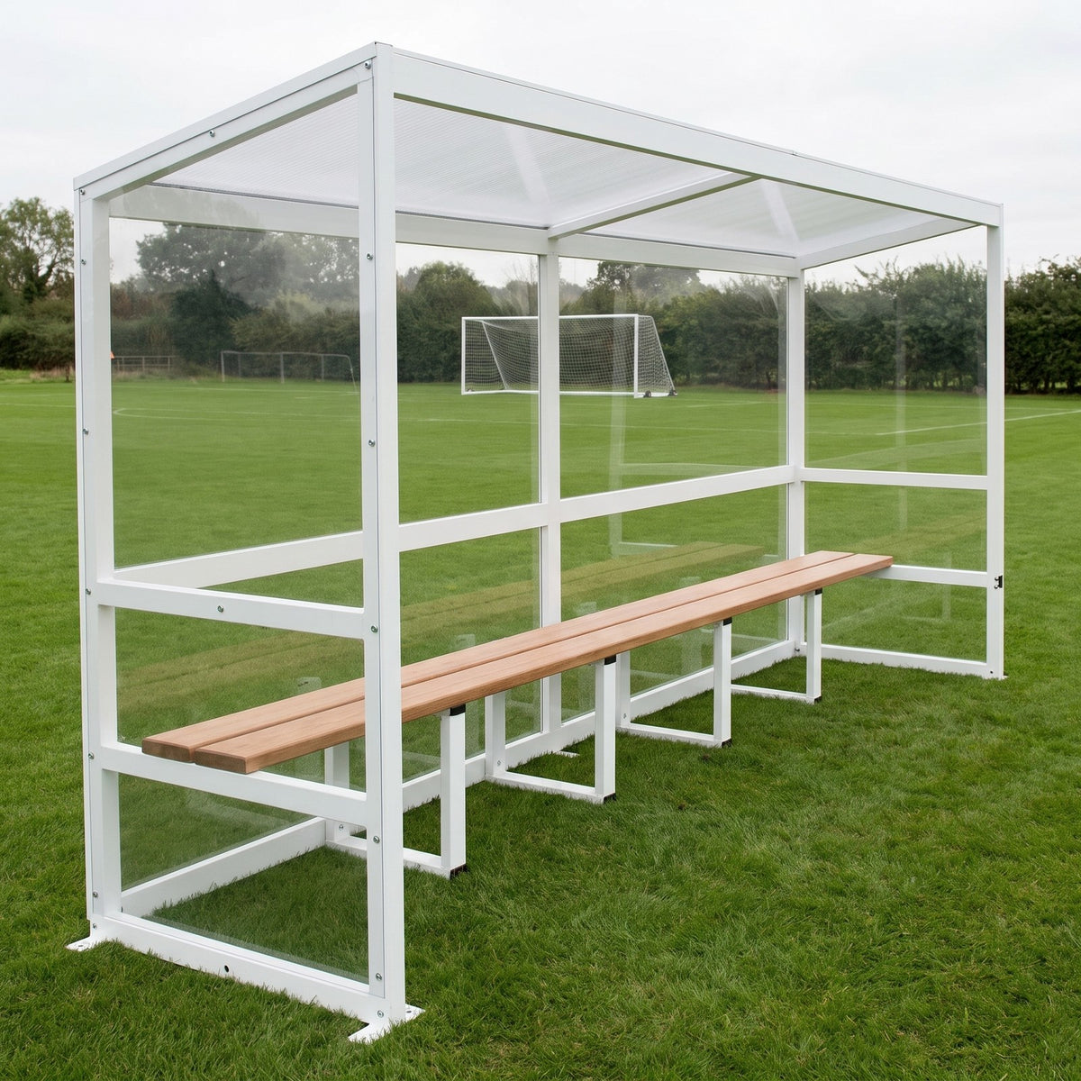 Freestanding aluminium eight person 4m team shelter beside a football pitch