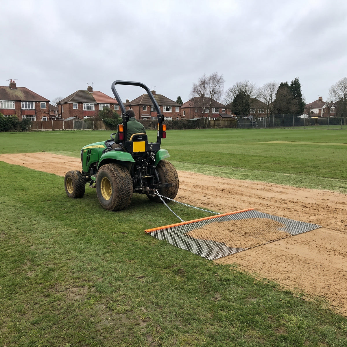 2.7m towed dragmat pulled behind a compact tractor, matting in sand top dressing on a sports pitch